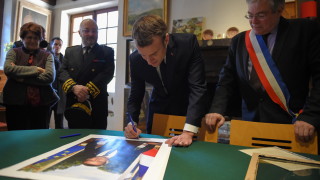 Двама протестиращи които са свалили портрет на президента Еманюел Макрон