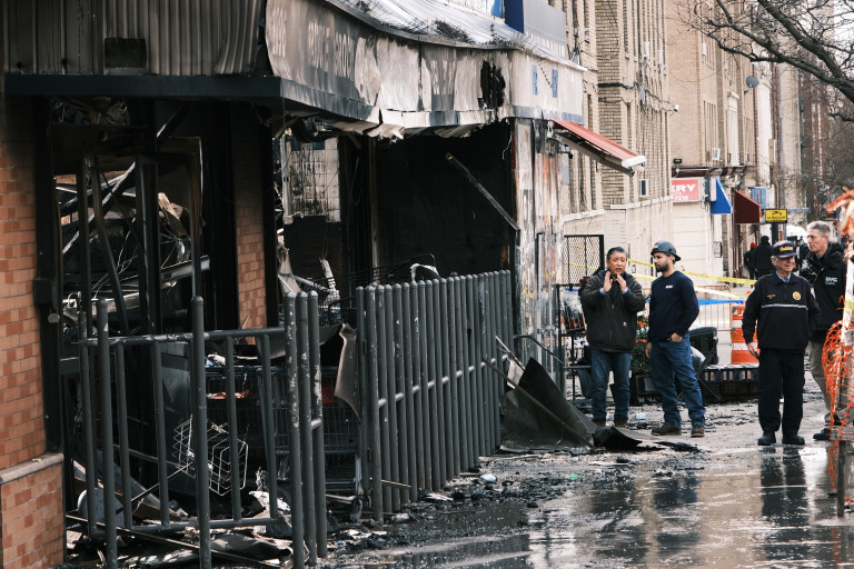 Служители на пожарната пред супермаркет в Бронкс ден след избухването на пожар, предизвикан от дефектна литиево-йонна батерия на 6 март 2023 г. в Ню Йорк. Въпреки че няма жертви при пожара, много хора бяха ранени и бяха необходими приблизително 200 пожарникари, за да овладеят огъня. Пожарите от тези батерии, които се използват все по-често в скутери и велосипеди, се увеличават.