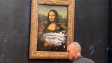 Мона Лиза и мъжът, преоблечен като жена, който замери картината с торта в Лувъра