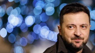 Снимка на украинския президент Володимир Зеленски позиращ пред картина изобразяваща